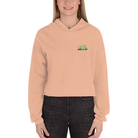 Woman wearing peach-colored cropped hoodie with Big Cat logo on left breast
